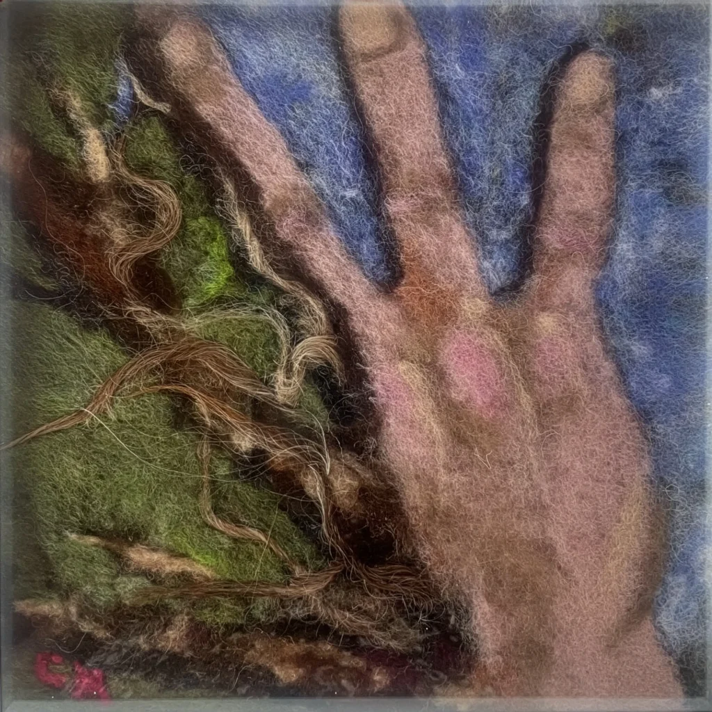 From the Same Earth, a felt artwork by Corina Hogan combining a human hand with forms from nature.