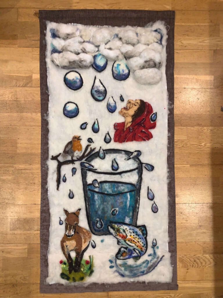 Nature’s Glass by Corina Hogan, a tall felt artwork showing water connecting people, animals and plants.